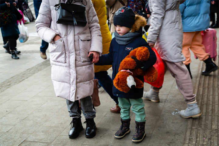 Ukrainian refugee child holding teddy bear