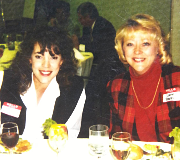 two women sitting at table, smiling