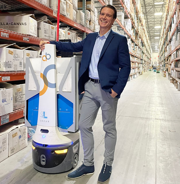 Ron Wittebort next to warehouse robot