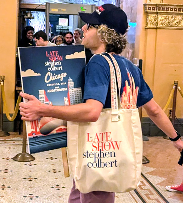 DNC goer holding Colbert tote bag