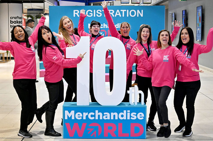 women from Sourcing City standing in front of trade show sign