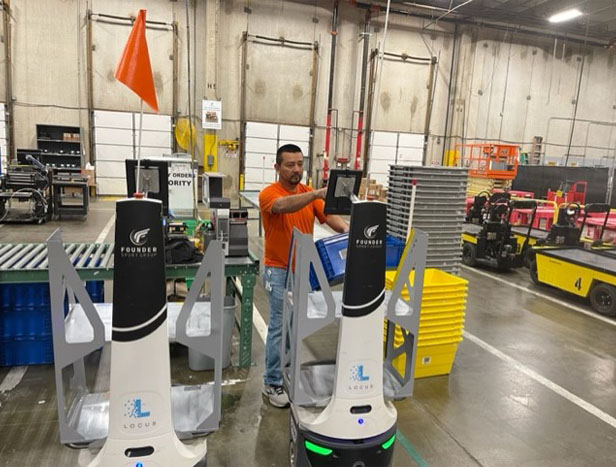 man in warehouse operating robots